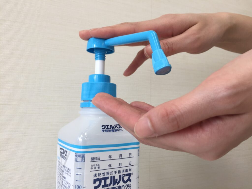 擦式アルコール製剤(ウエルパス)のディスペンサーを押すところ
