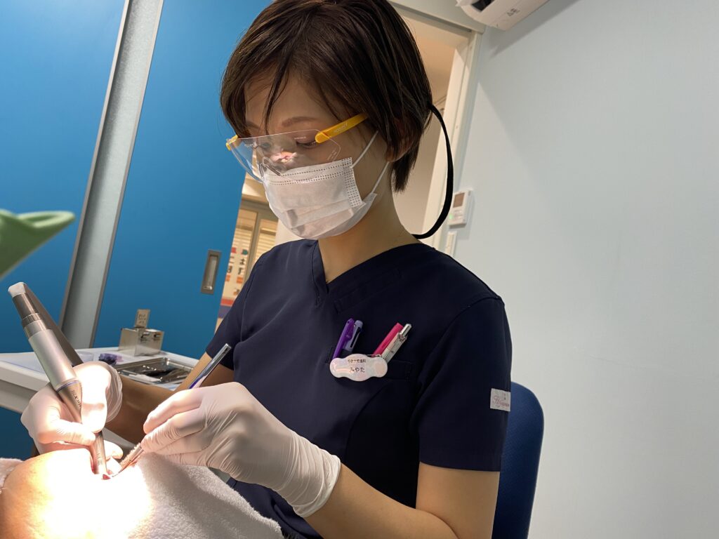 診療中にゴーグルとマスクを着用した歯科衛生士